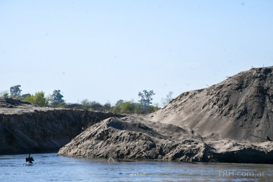Maquinarias pesadas trabajando en el cauce del río Dulce para reforzar defensas