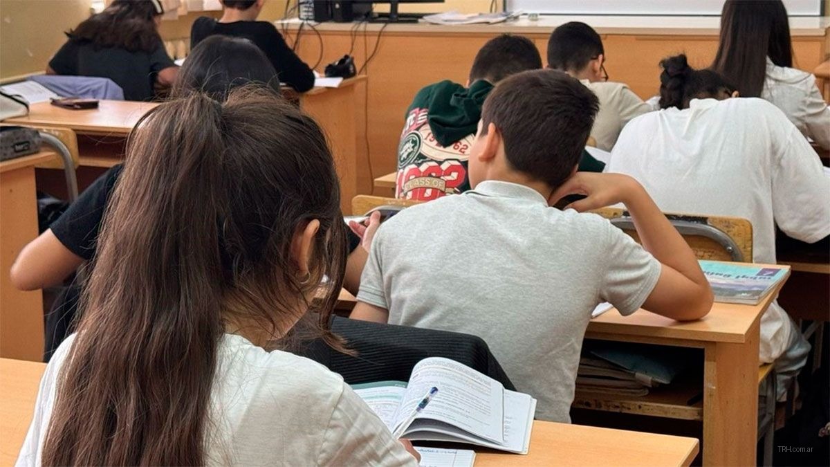 Alumnos secundarios realizando tareas de matemática y lectura
